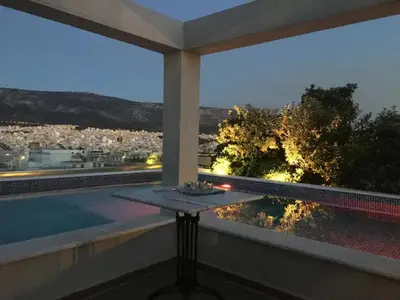 a balcony with a table and a view of a city at Athens Lycabettus Hill Penthouse, Private Roof Garden & Pool in Athens