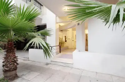 a building with palm trees in front of it at Athens Lycabettus Hill Penthouse, Private Roof Garden & Pool in Athens