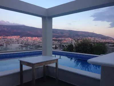 a balcony with a table and a view of a city at Athens Lycabettus Hill Penthouse, Private Roof Garden & Pool in Athens