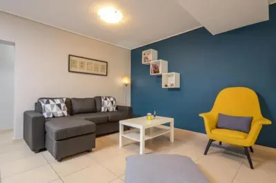 a living room with a couch and a yellow chair at Boutique Apartments in Athens in Athens