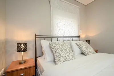 a bedroom with a bed and a lamp on a table at Boutique Apartments in Athens in Athens