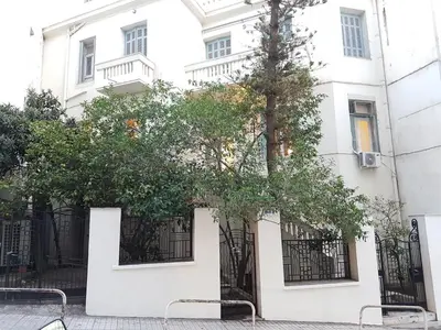 a white building with a tree in front of it at Errathens Aegean Apartment - Athens Center, 5 BD, 2 BATH in Athens