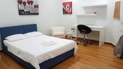 a bedroom with a bed and a desk and a chair at Errathens Pine Red and Taupe - Athens Center in Athens