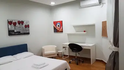 a bedroom with a bed and a desk with a chair at Errathens Pine Red and Taupe - Athens Center in Athens