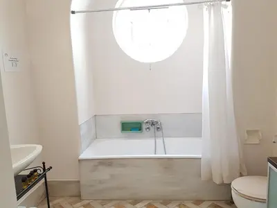 a bathroom with a bath tub with a window at Errathens Pine Red and Taupe - Athens Center in Athens