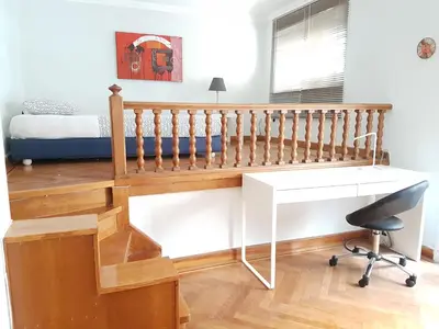 a bedroom with a staircase and a desk and a bed at Errathens Pine Red and Taupe - Athens Center in Athens