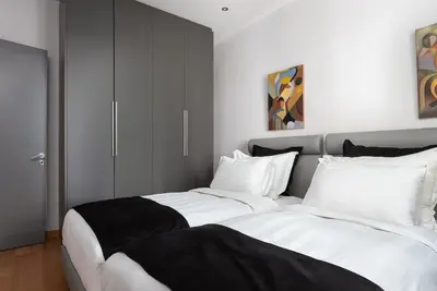 a bedroom with two beds with white and black sheets at Acropolis Elegant Penthouse in Athens