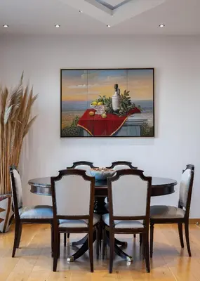 a dining room table with chairs and a painting on the wall at Acropolis Elegant Penthouse in Athens