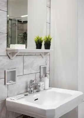 a bathroom with a white sink and a mirror at Acropolis Elegant Penthouse in Athens