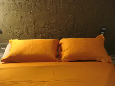 two yellow pillows sitting on top of a bed at Soho Athene Apartment in Athens