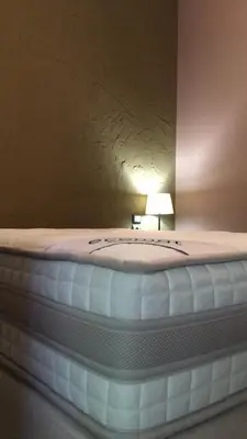 a bed with a white mattress with a lamp on it at Soho Athene Apartment in Athens