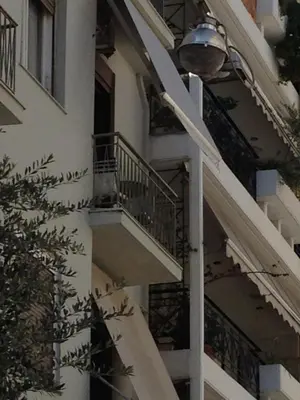 a street light next to a building with a balcony at Soho Athene Apartment in Athens
