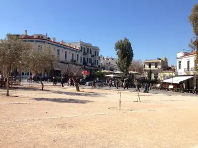 a group of people walking around a plaza in a city at Soho Athene Apartment in Athens