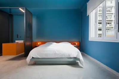 a blue bedroom with a bed and a window at Syntagma Square Modern Apartments in Athens