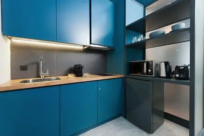 a kitchen with blue cabinets and a sink at Syntagma Square Modern Apartments in Athens