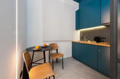 a kitchen with blue cabinets and a table and chairs at Syntagma Square Modern Apartments in Athens