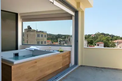 a bathroom with a tub with a large window at Acropolis View Luxury Apartment in Athens