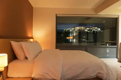 a bedroom with a bed and a large window at Acropolis View Luxury Apartment in Athens