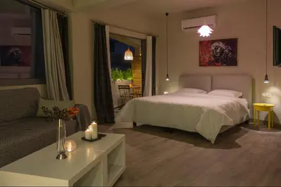 a bedroom with a bed and a couch and a table at Athens Suites in Athens