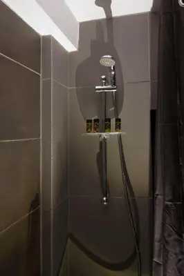 a shower with a shower head in a bathroom at Athens Suites in Athens