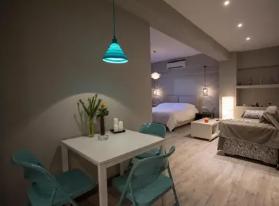 a room with a table and chairs and a bed at Athens Suites in Athens