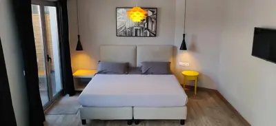 a small bedroom with a bed and a tv at Athens Suites in Athens