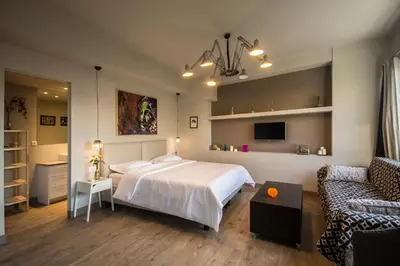 a bedroom with a white bed and a couch at Athens Suites in Athens