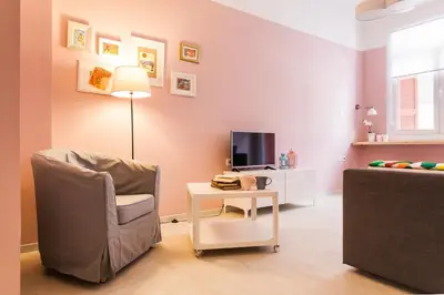 a living room with a chair and a tv and a table at Karitsi Place in Athens