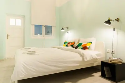 a bedroom with a white bed with colorful pillows at Karitsi Place in Athens