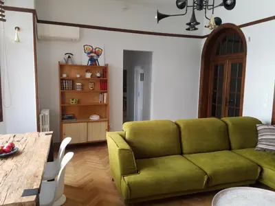 a living room with a green couch and a table at Kolonaki Deco Apartment in Athens