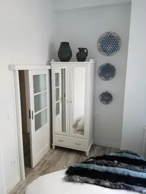 a bedroom with a white cabinet and a mirror at Kolonaki Deco Apartment in Athens