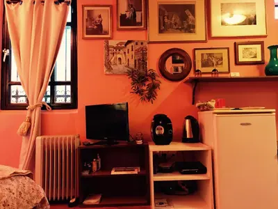 a room with an orange wall with a refrigerator at Gallery Basement in Villa Vravrona in Markopoulo