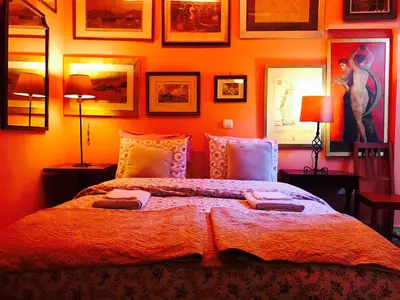a bedroom with a large bed with orange walls at Gallery Basement in Villa Vravrona in Markopoulo