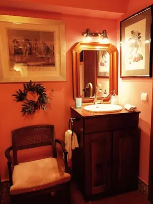 a bathroom with a sink and a mirror and a chair at Gallery Basement in Villa Vravrona in Markopoulo
