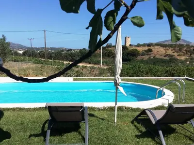 a swimming pool in a yard with two chairs at Gallery Basement in Villa Vravrona in Markopoulo