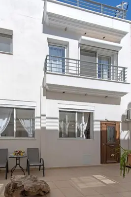 a white building with a balcony and a patio at Townhouse in the Historical Centrer of Athens in Athens