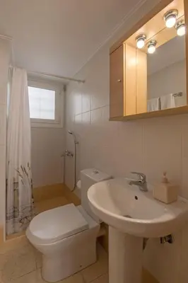 a white bathroom with a toilet and a sink at Townhouse in the Historical Centrer of Athens in Athens