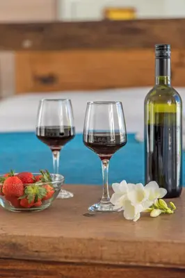 two wine glasses and a bottle of wine and strawberries at Townhouse in the Historical Centrer of Athens in Athens