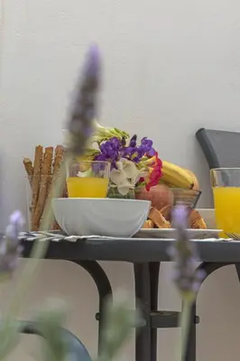 a table with a plate of food and flowers on it at Townhouse in the Historical Centrer of Athens in Athens