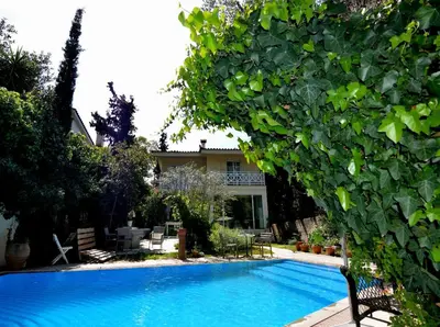 a large blue swimming pool in front of a house at St. Thomas Bed and Breakfast in Paianía