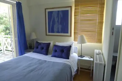 a bedroom with a large white bed with blue pillows at St. Thomas Bed and Breakfast in Paianía