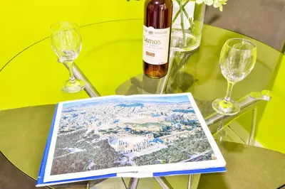 a wine bottle and a book on a table with glasses at Lofos Apartment in Athens