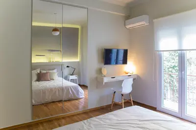 a bedroom with a bed and a desk with a television at Muses Residence in Athens