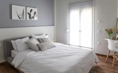 a white bedroom with a large white bed and a window at Muses Residence in Athens