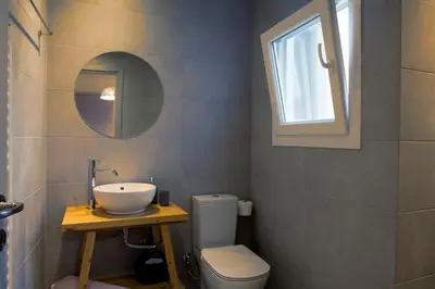 a bathroom with a sink and a toilet and a mirror at Muses Residence in Athens
