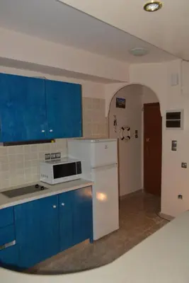 a kitchen with blue cabinets and a white appliance at Cosy apartment Acropolis Point-3 in Athens