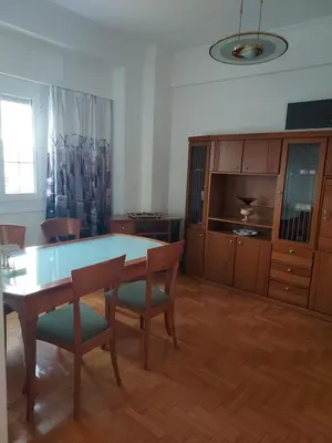 a living room with a table and chairs and a tv at Pasalimani Long Beach in Piraeus