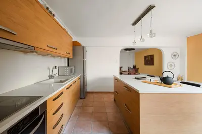 a kitchen with wooden cabinets and a white counter top at Villa Saronida in Saronida