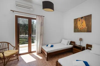 a bedroom with a bed and a window with a balcony at Villa Saronida in Saronida