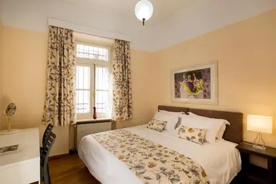 a bedroom with a large bed and a window at Acropolis Neoclassical Mansion by YHA in Athens